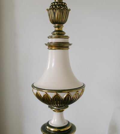 A balanced pair of tall vintage Stiffel porcelain and brass table lamps, styled here in a quiet, symmetrical entryway arrangement