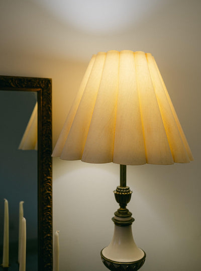 A balanced pair of tall vintage Stiffel porcelain and brass table lamps, styled here in a quiet, symmetrical entryway arrangement