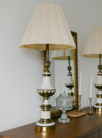 A balanced pair of tall vintage Stiffel porcelain and brass table lamps, styled here in a quiet, symmetrical entryway arrangement
