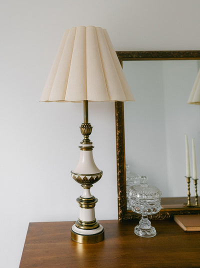 A balanced pair of tall vintage Stiffel porcelain and brass table lamps, styled here in a quiet, symmetrical entryway arrangement