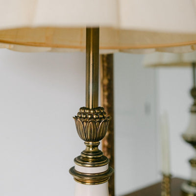 A balanced pair of tall vintage Stiffel porcelain and brass table lamps, styled here in a quiet, symmetrical entryway arrangement