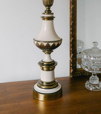 A balanced pair of tall vintage Stiffel porcelain and brass table lamps, styled here in a quiet, symmetrical entryway arrangement