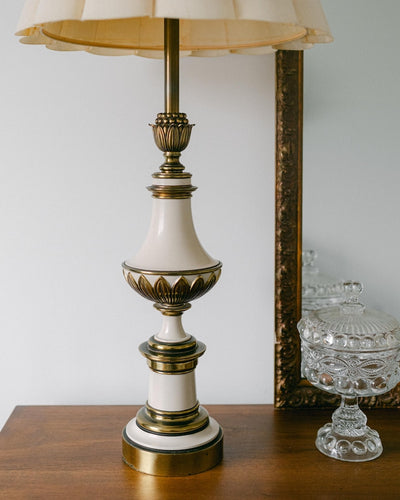 A balanced pair of tall vintage Stiffel porcelain and brass table lamps, styled here in a quiet, symmetrical entryway arrangement